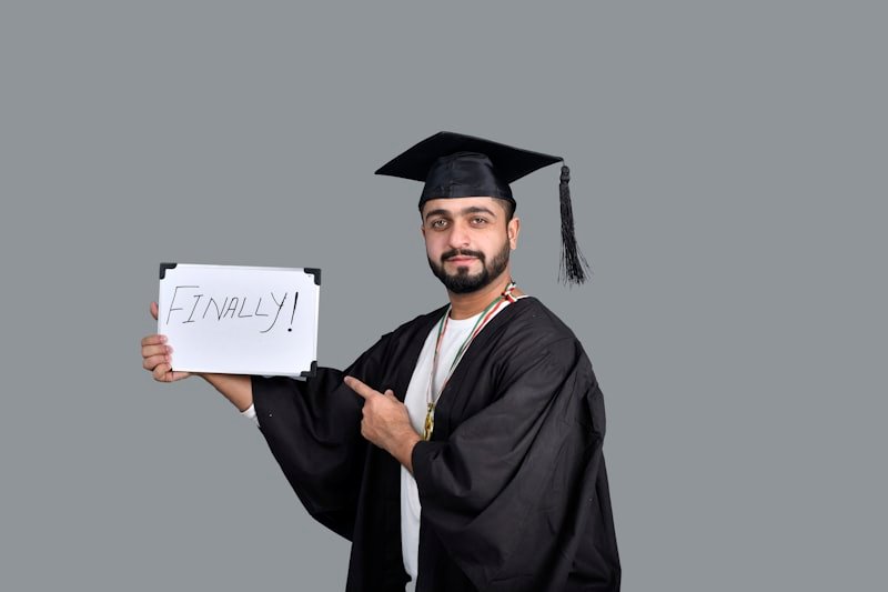 a person wearing a graduation cap and gown holding a sign